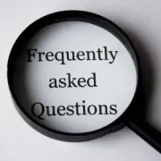 Magnifying glass over the words “Frequently asked Questions” on a white background