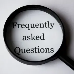 Magnifying glass over the words “Frequently asked Questions” on a white background