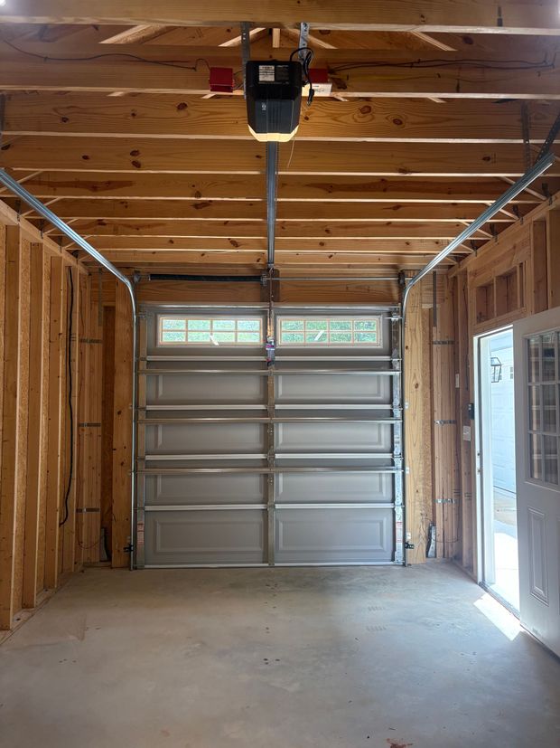Man in garage using smartphone to control the garage door opener.
