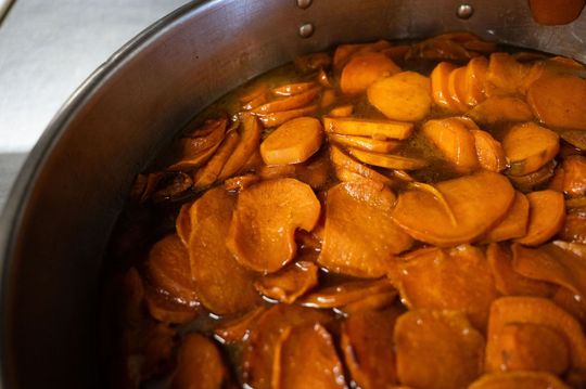 Pot of sliced carrots simmering in orange broth