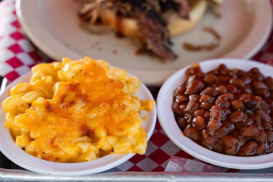 Two bowls of baked beans and scrambled eggs on a red-and-white checkered tablecloth