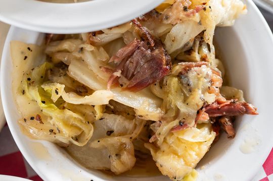 Close-up of a creamy pasta dish with shredded meat in a white bowl