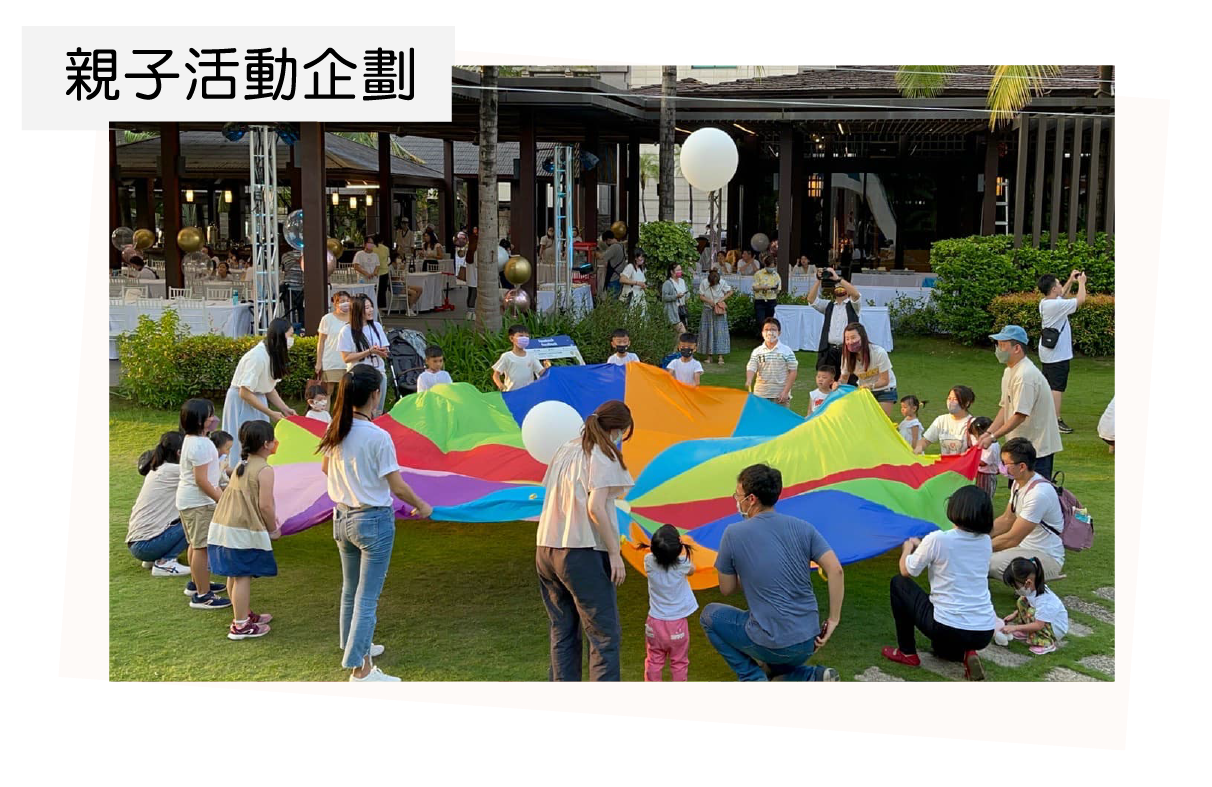 A group of people are playing with a parachute in a park.
