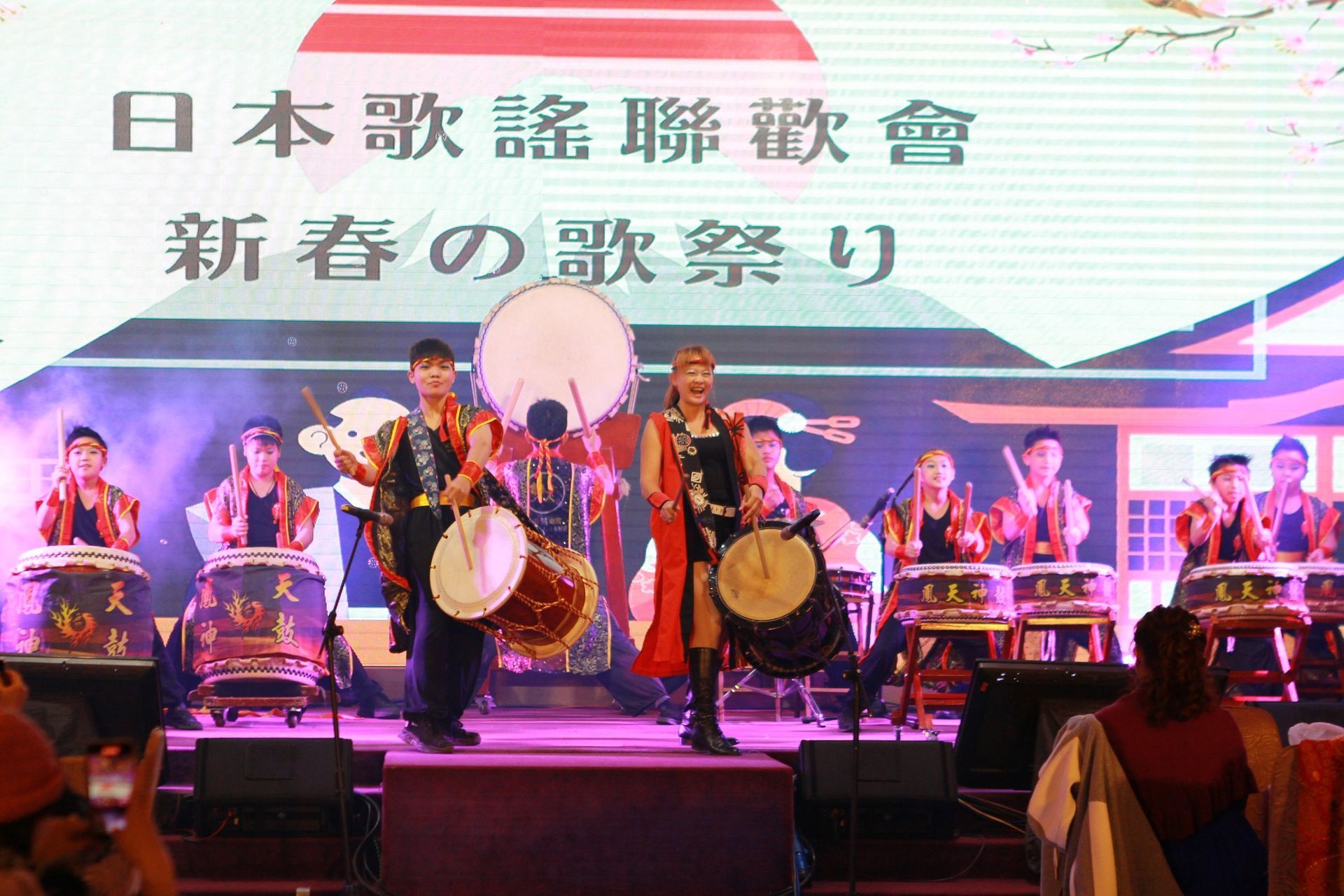 A group of people are playing drums on a stage.