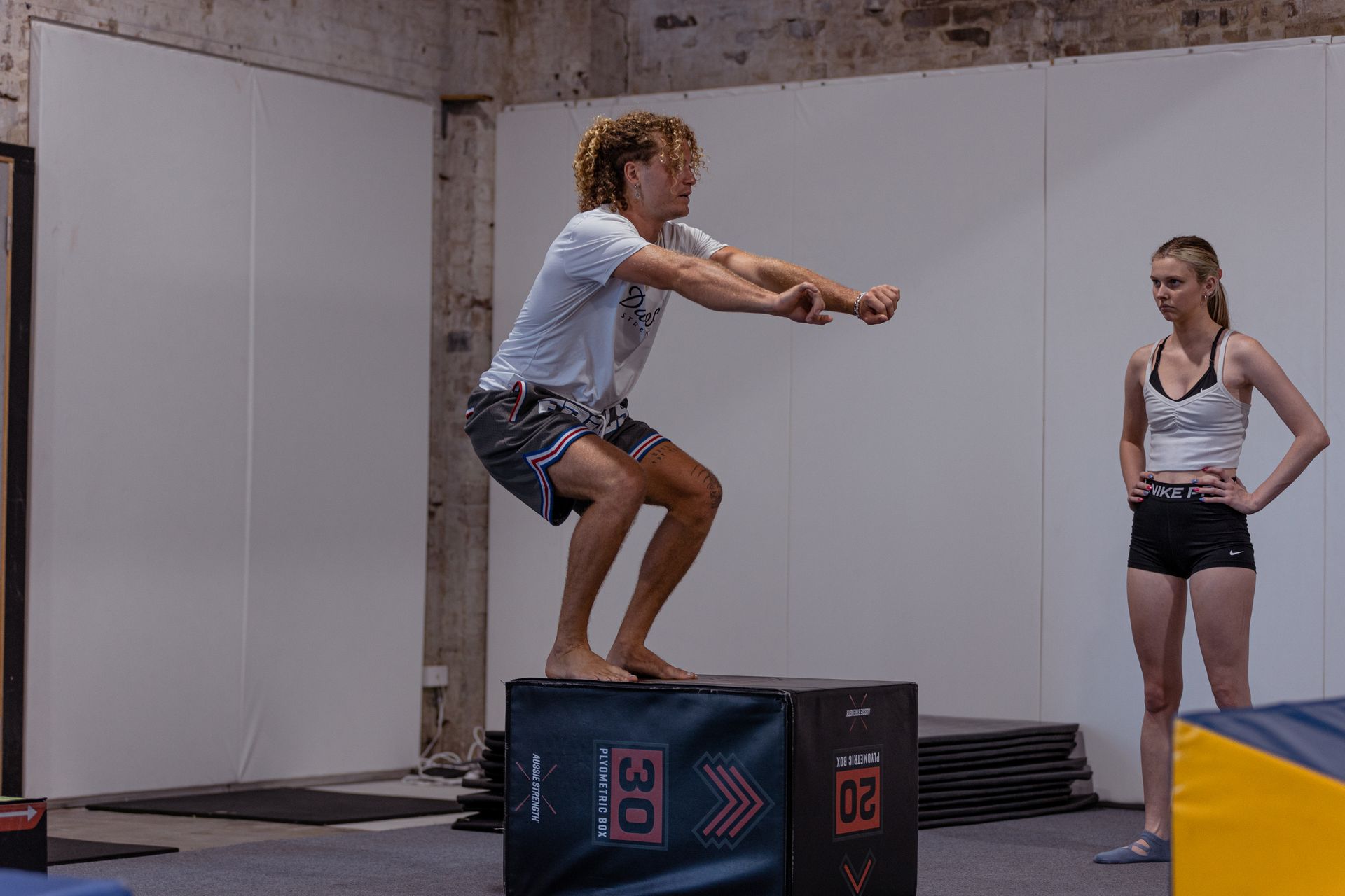 Image of a guy explaining how to do a exercise to a girl