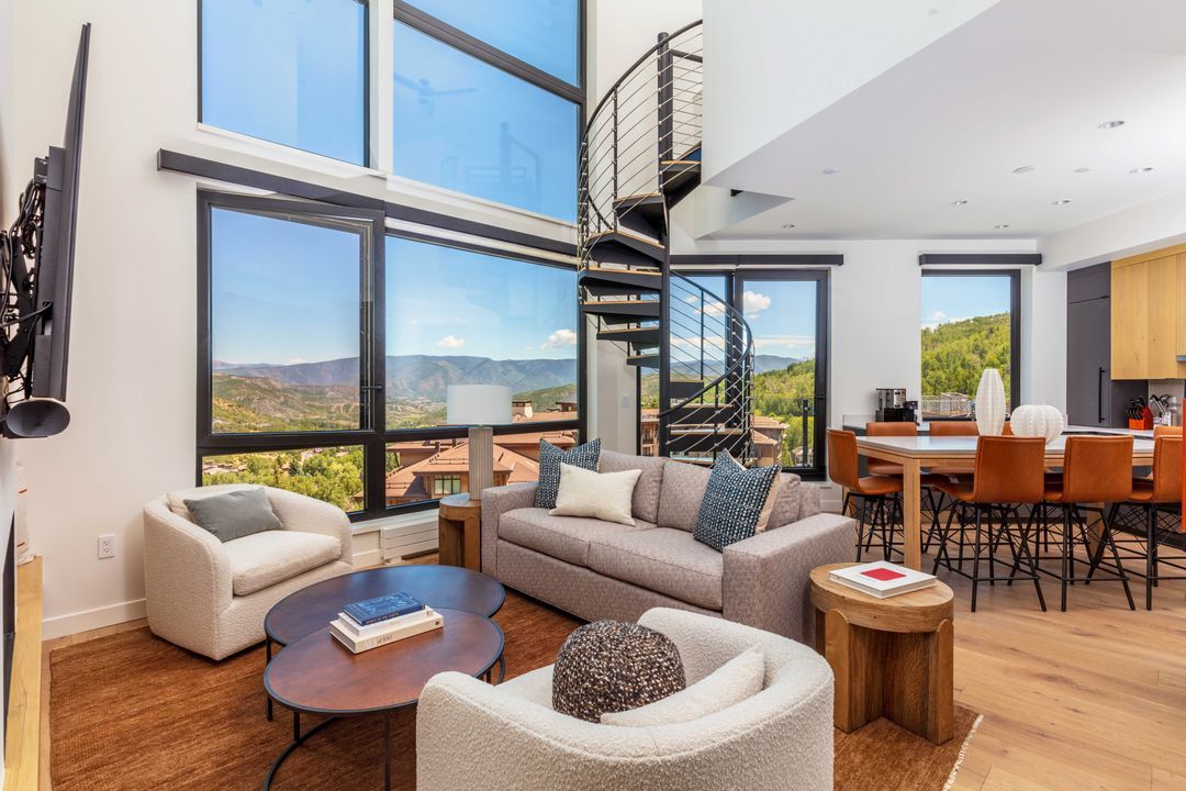 A living room filled with furniture and a spiral staircase.