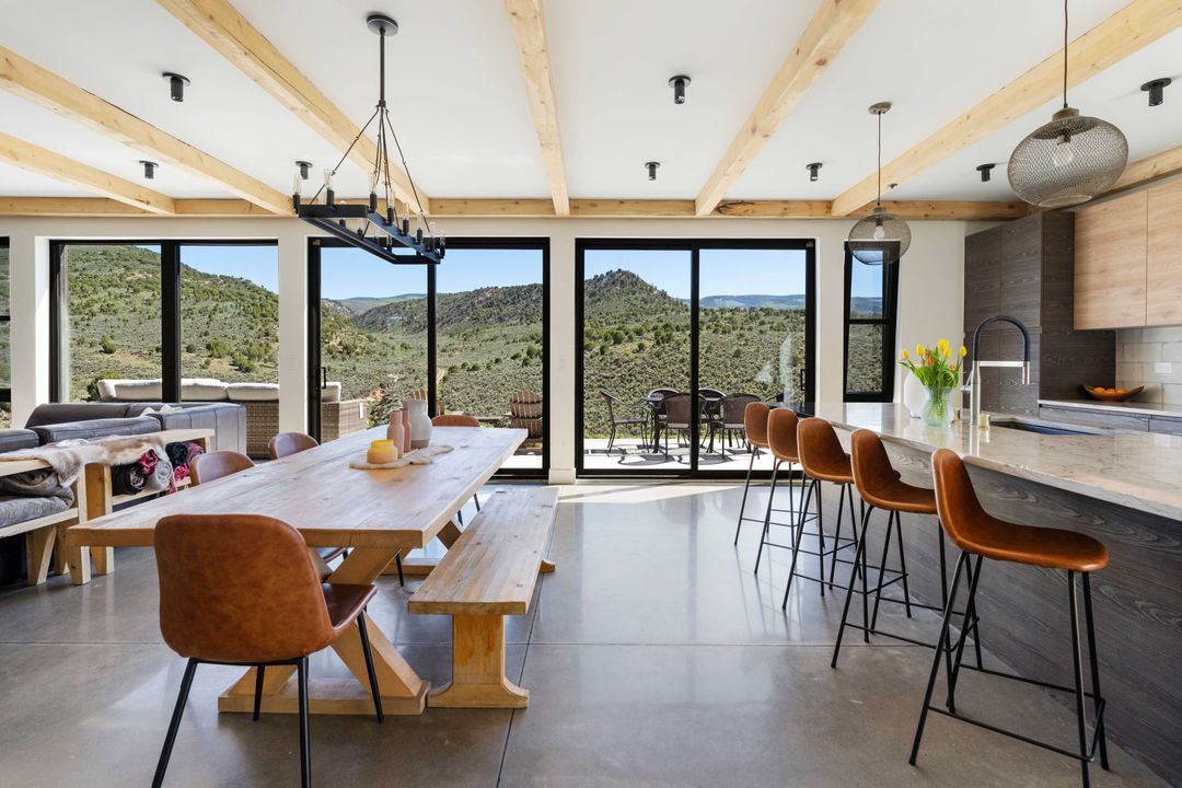 A large living room with a dining table and chairs and a kitchen.