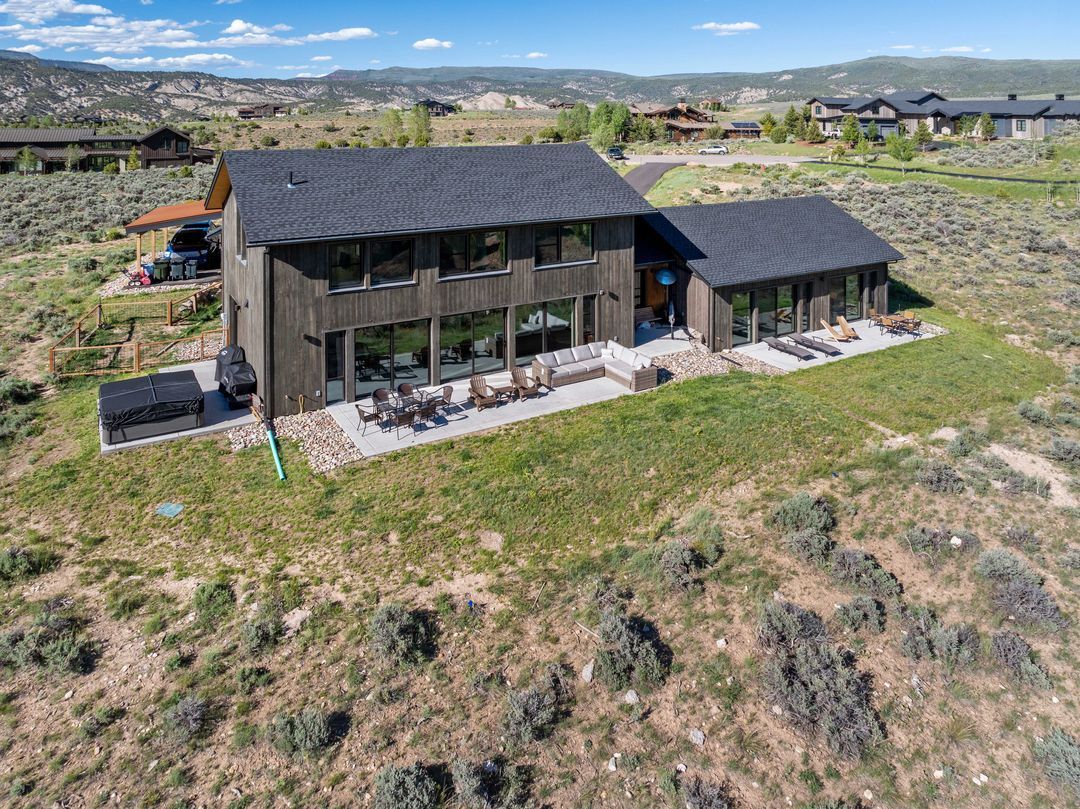 An aerial view of a large house in the middle of a field.