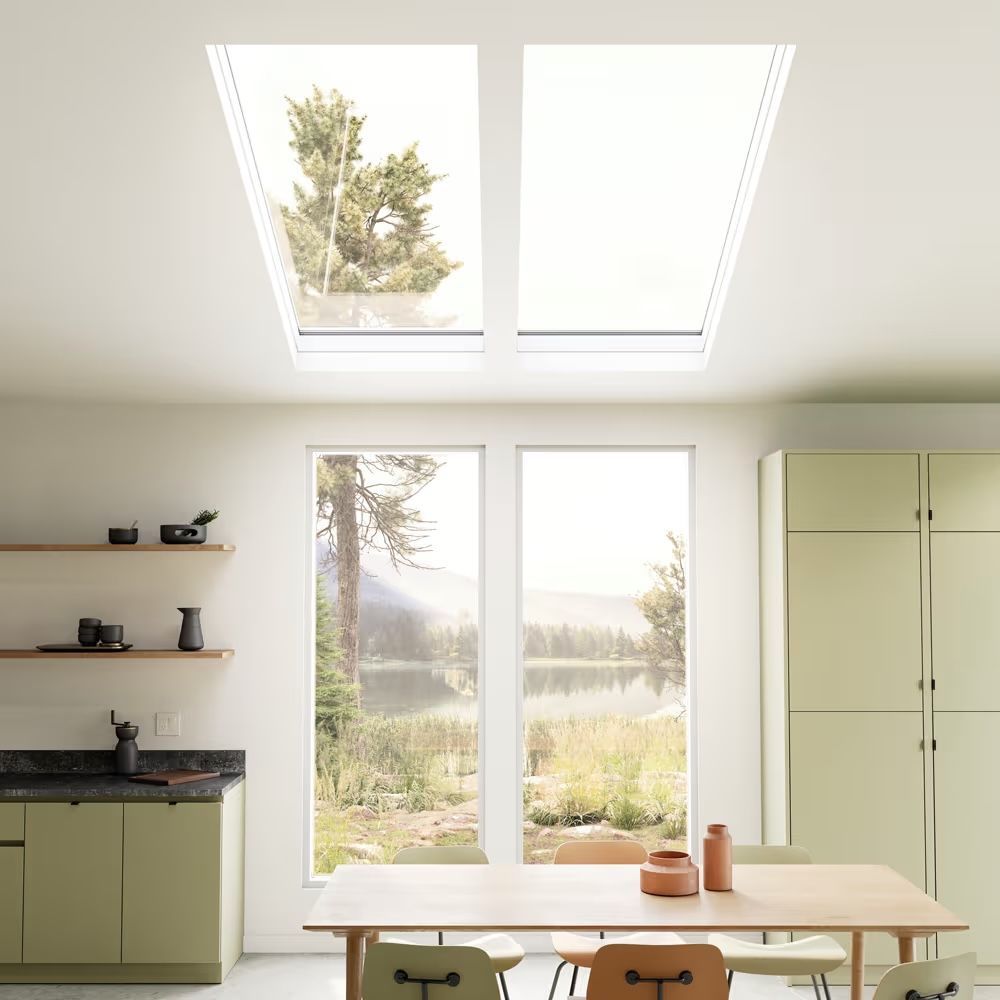 A kitchen with a table and chairs under a skylight