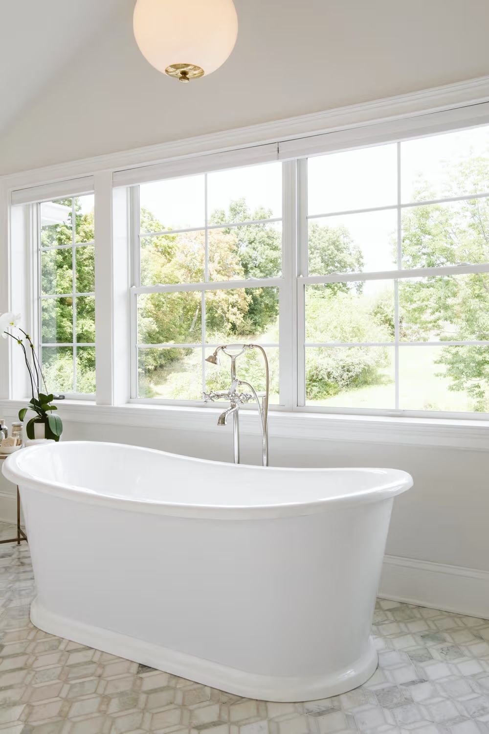 There is a bathtub in the bathroom with a lot of windows.