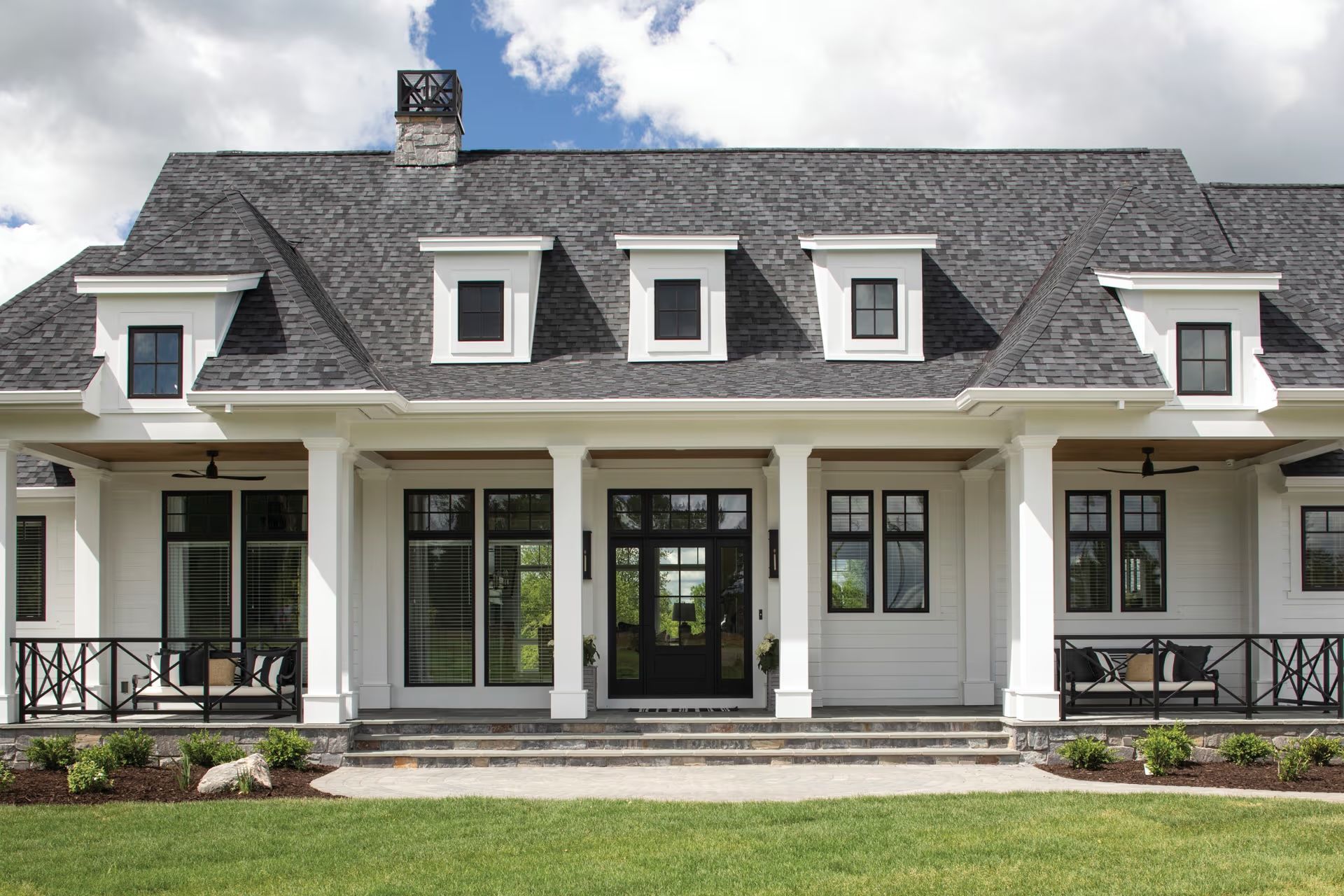 A large white house with a gray roof and black windows