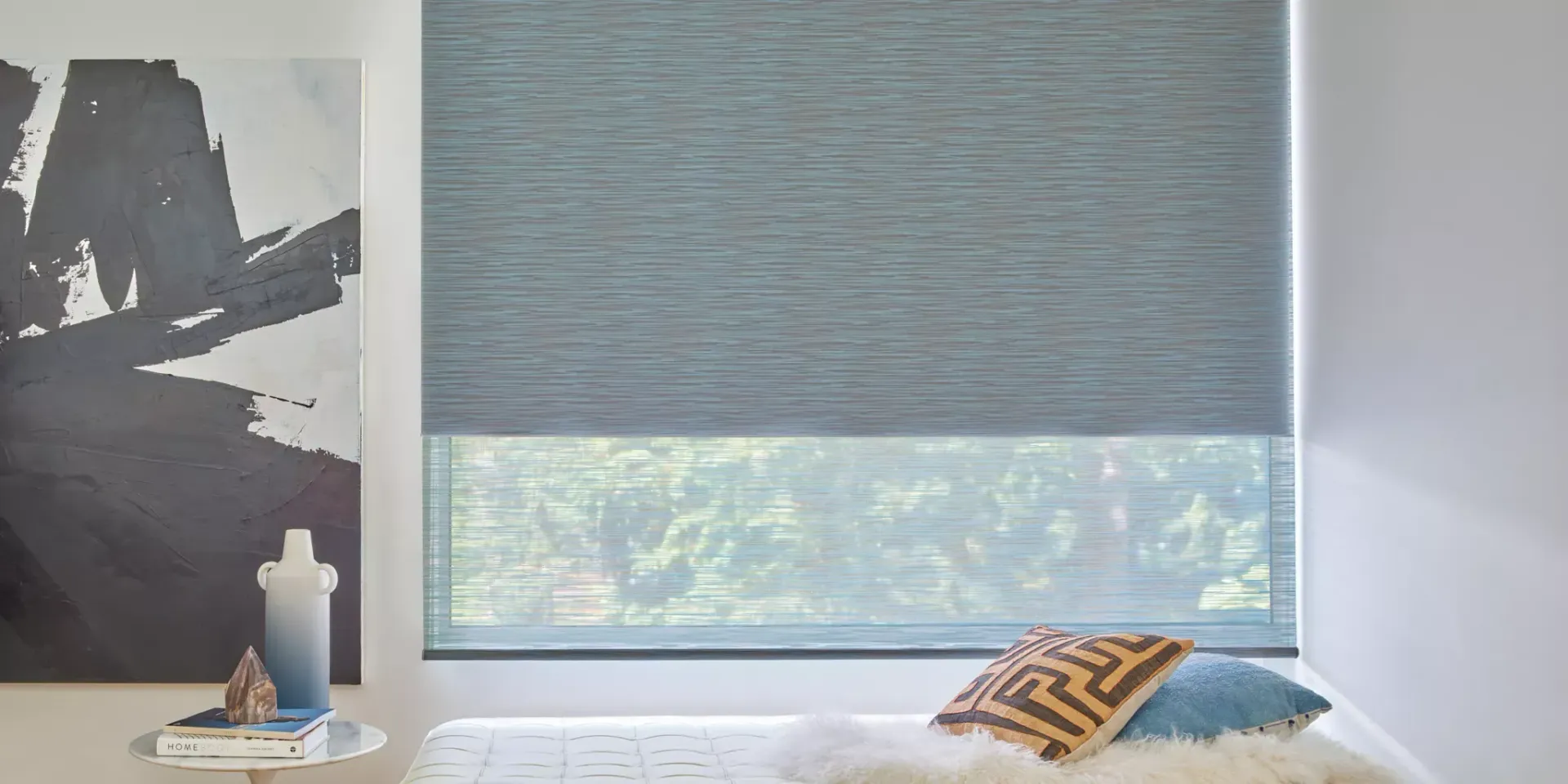 A bedroom with a bed and a window with a blue blind.