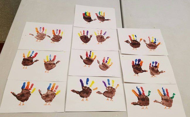 A bunch of hand prints of turkeys on a table