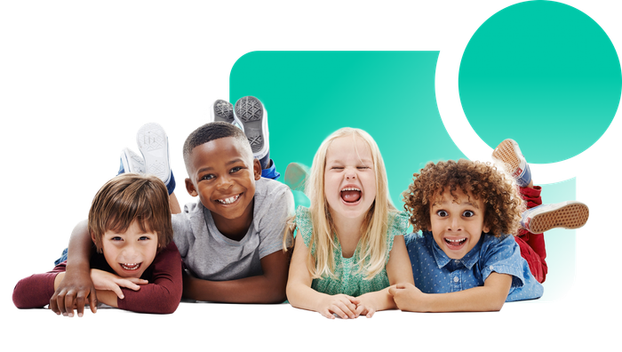A group of children are laying on the floor together and smiling.