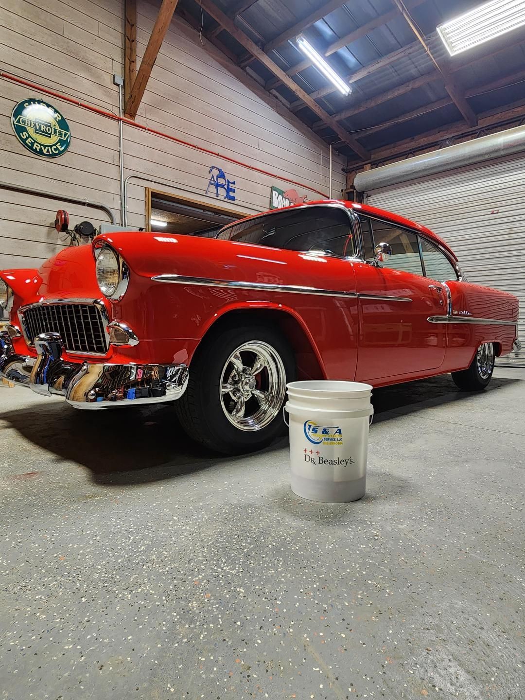 A Glossy Red Vintage Car Parked in a Garage Next to a White Bucket — Valentine Detailing LLC in Walterboro, SC