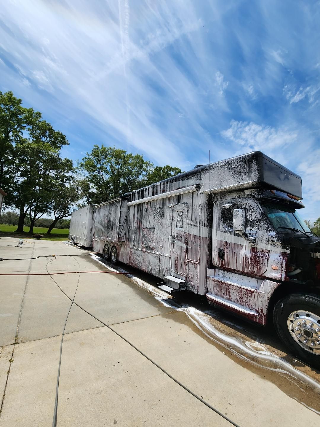 A Semi-truck Covered in White Soap Suds Parked on a Concrete Lot — Valentine Detailing LLC in Walterboro, SC