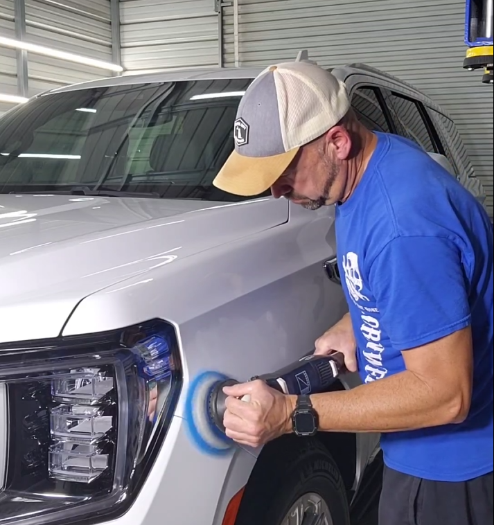 A Person Wearing a Ball Cap and Blue Shirt Uses a Powered Buffer — Valentine Detailing LLC in Walterboro, SC