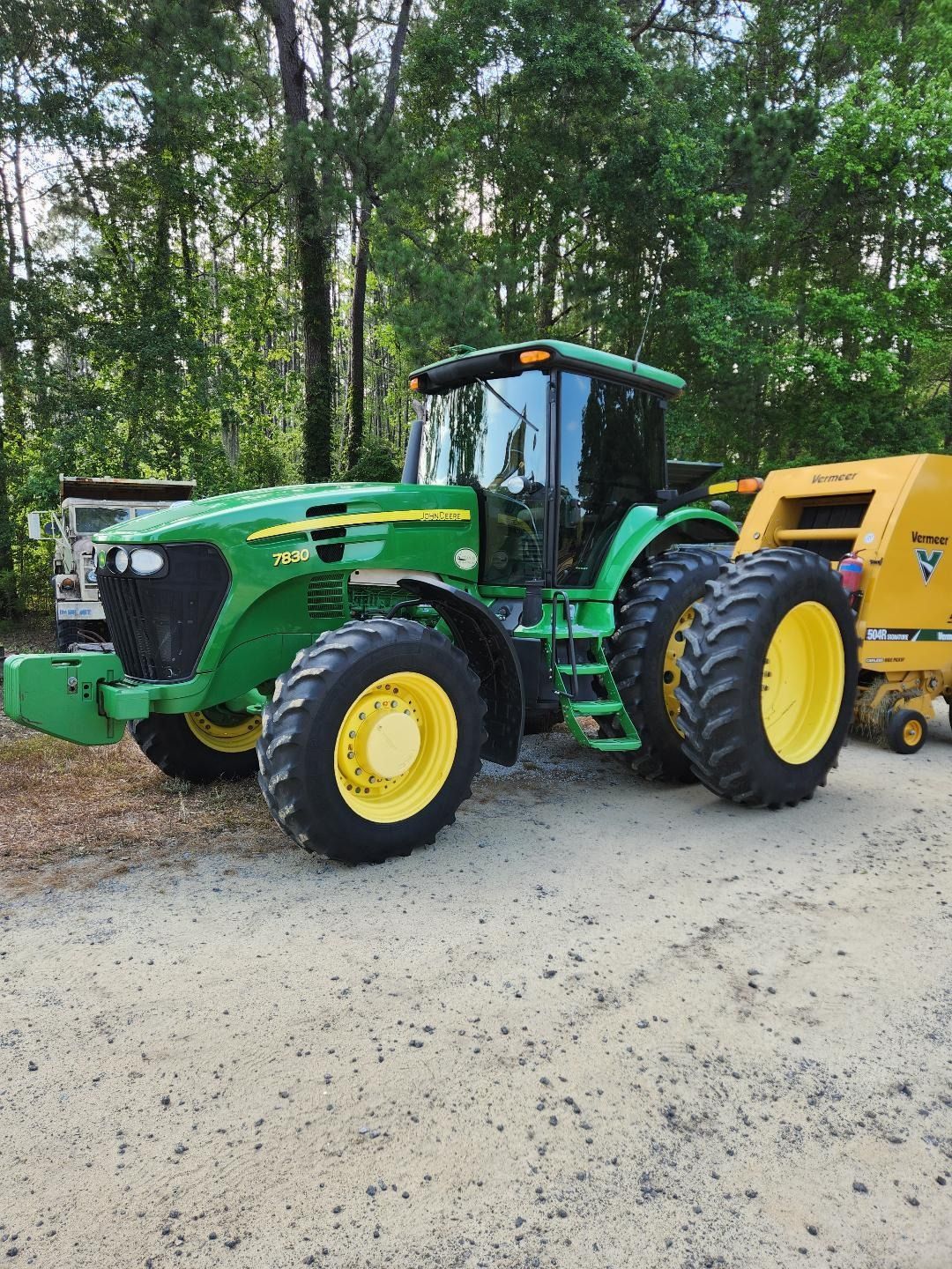 A Green John Deere Tractor With Dual Rear Tires is Parked on a Dirt Path — Valentine Detailing LLC in Walterboro, SC
