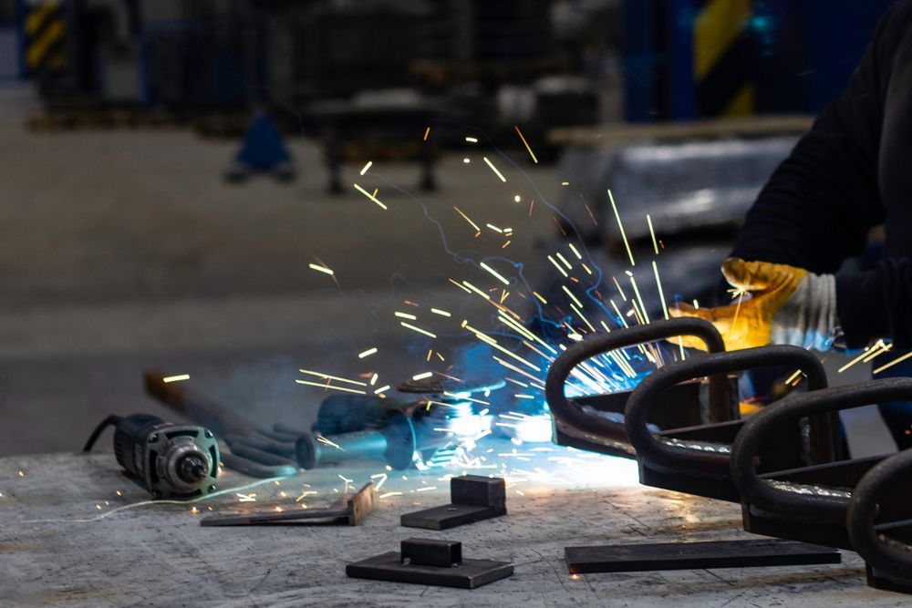 A Welder Working in a Metal Pieces — Absolute Steel Fabrication & Welding In East Wagga Wagga, NSW