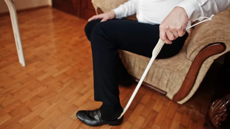 senior man using a shoehorn