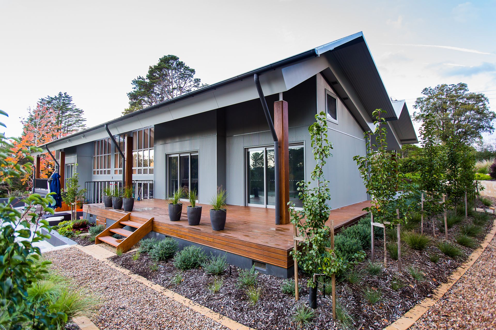 A small house with a wooden deck and stairs  — GMT Builders Pty Ltd in Bowral, NSW