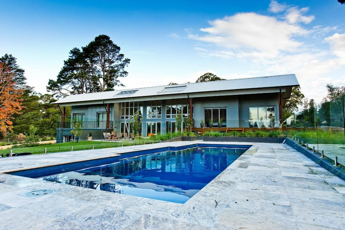 A Large House with A Swimming Pool in Front of It — GMT Builders Pty Ltd in Berrima, NSW