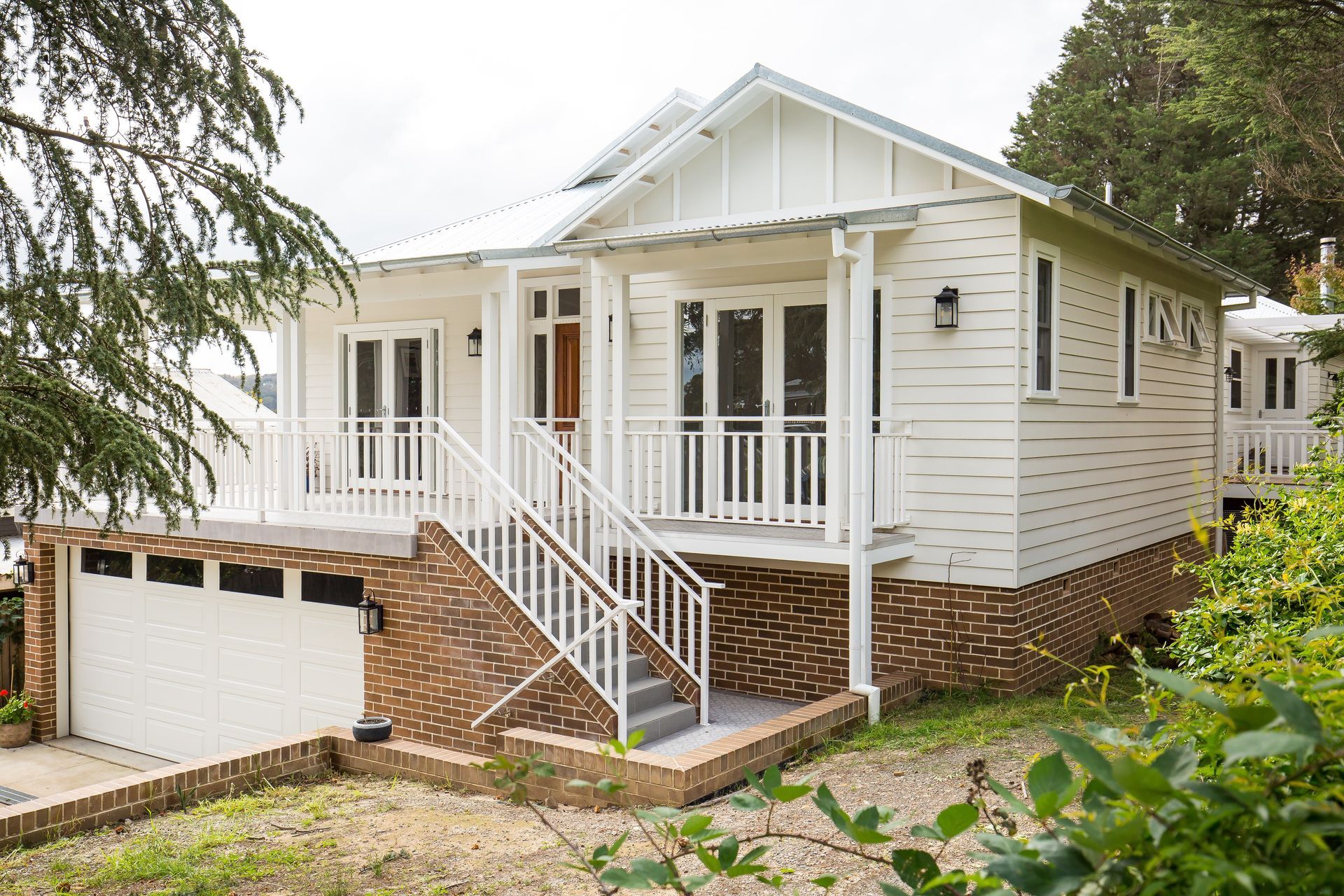A Gray House with White Chairs on The Porch — GMT Builders Pty Ltd in Berrima, NSW