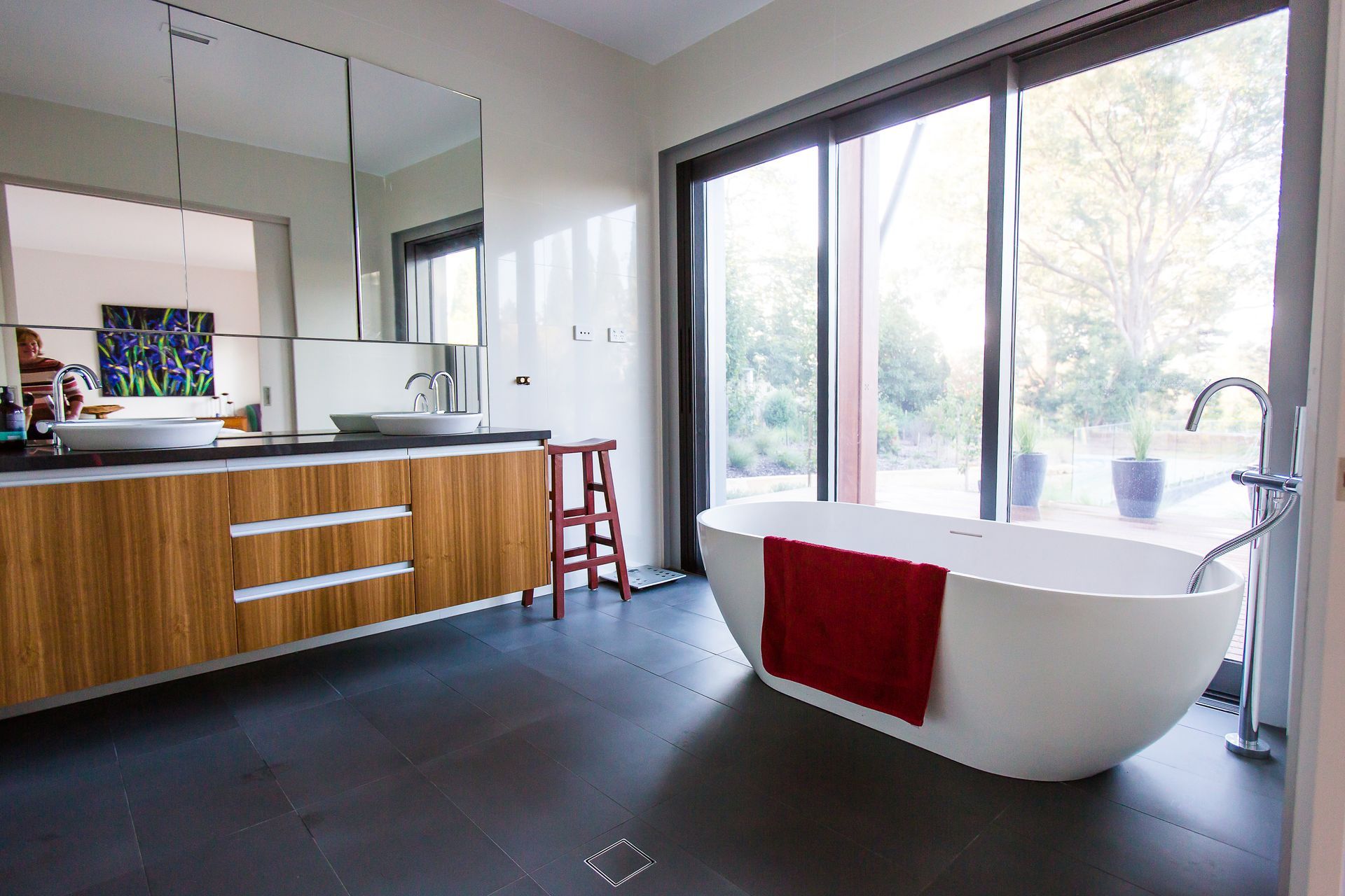 A bathroom with a bathtub, sink, mirror and sliding glass doors — GMT Builders Pty Ltd in Sunninghill, NSW