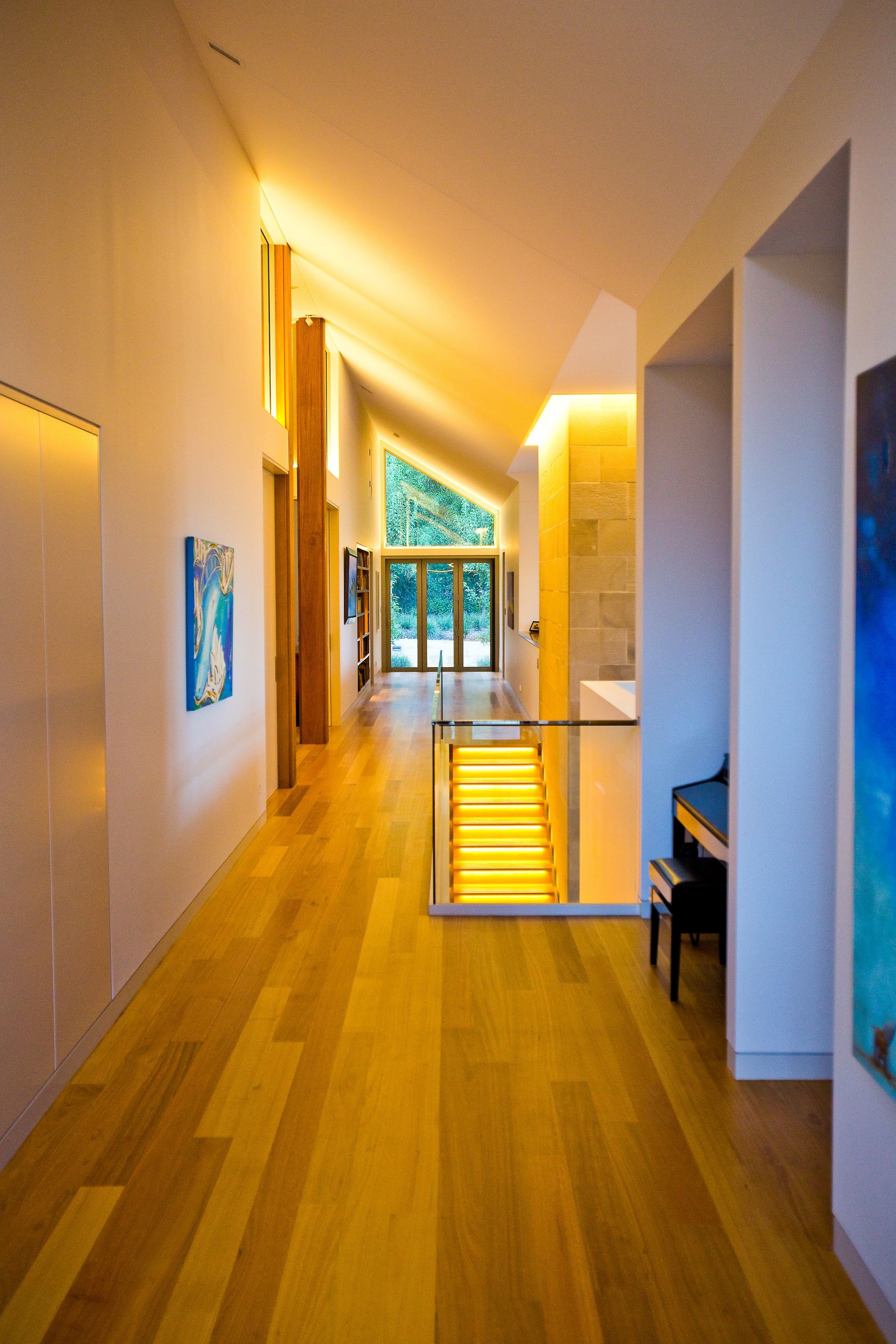 A long hallway with wooden floors and stairs in a house — GMT Builders Pty Ltd in Berrima, NSW