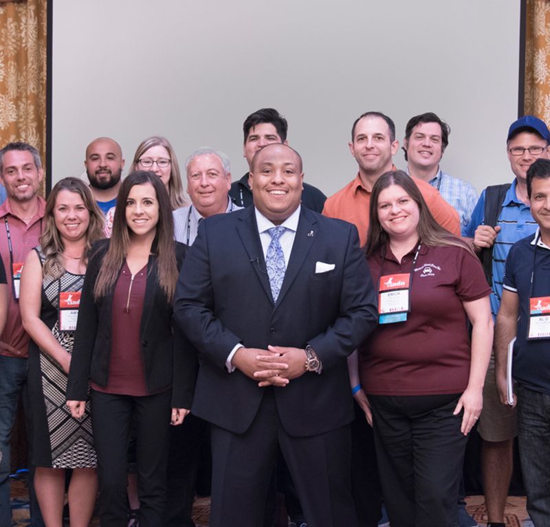 A group of people posing for a picture with a man in a suit and tie