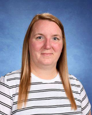 A woman in a striped shirt is posing for a picture.