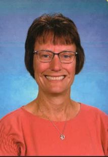 A woman in a red dress is smiling for the camera.