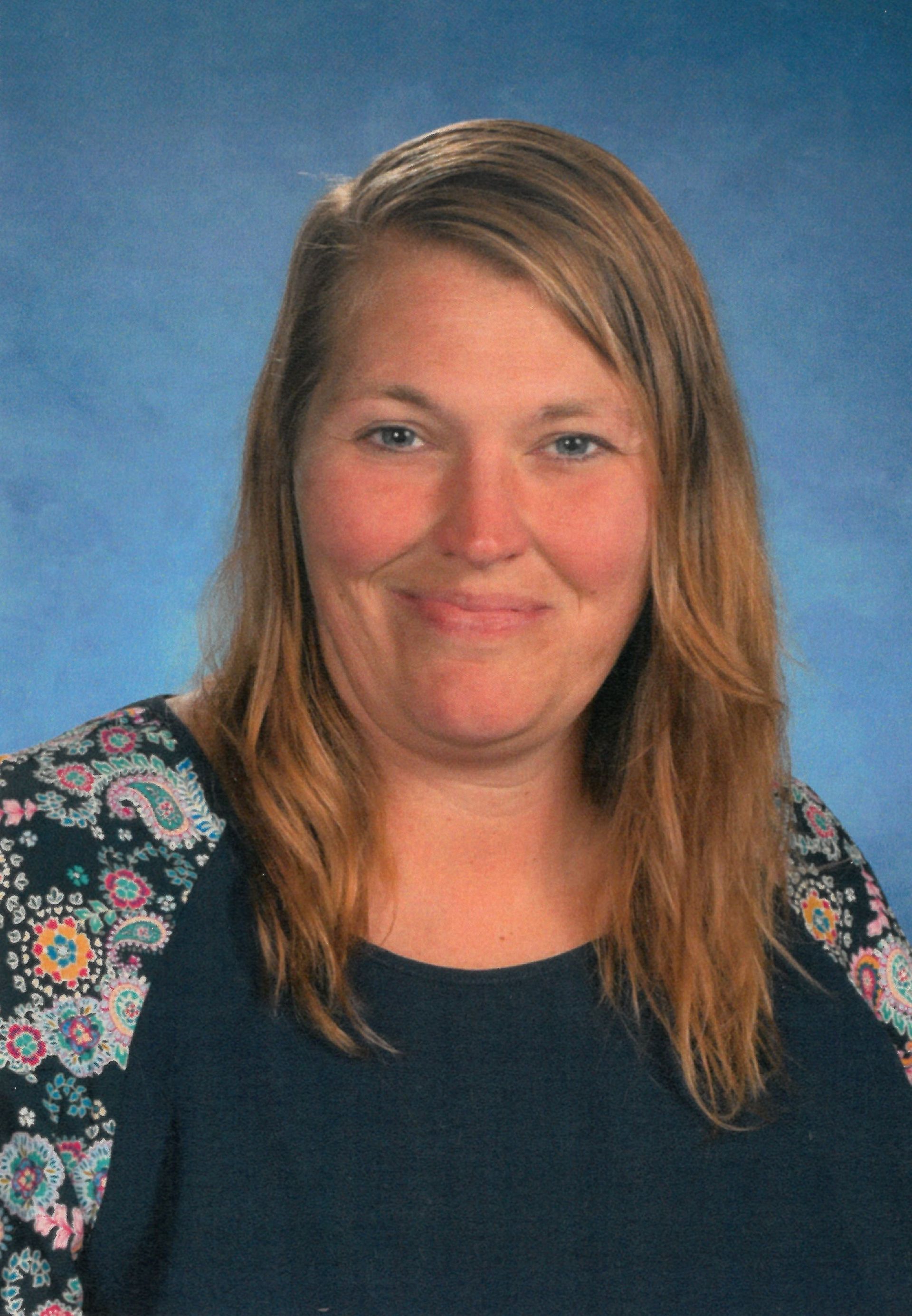 A woman in a patterned shirt is smiling for the camera. This is Amy Traucht.