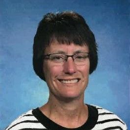 A woman in a red dress is smiling for the camera.