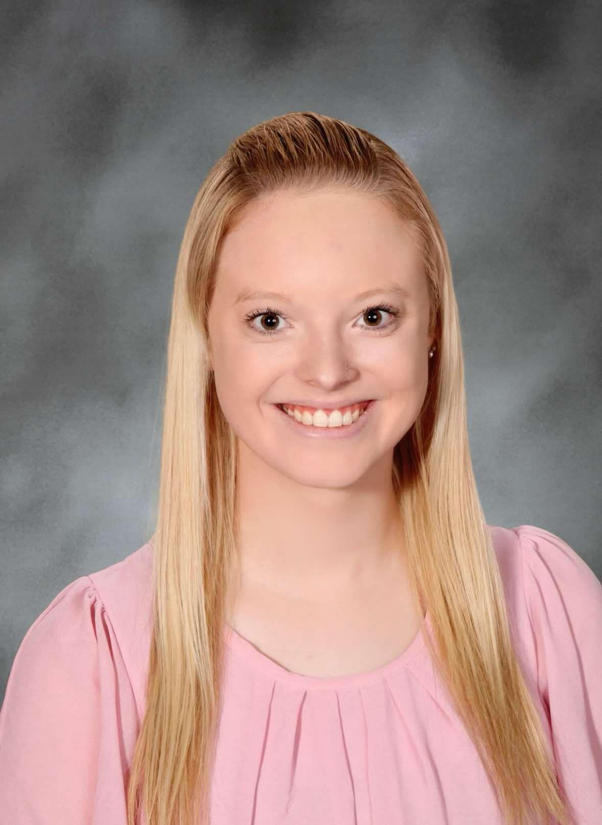 A woman wearing glasses and a white jacket is smiling for the camera. This is michelle Porter.