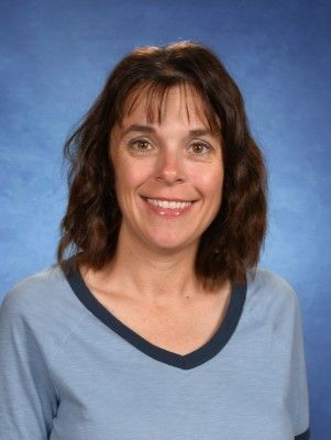 A woman in a blue shirt is smiling for the camera. This is Mrs. Stacy Clausing.