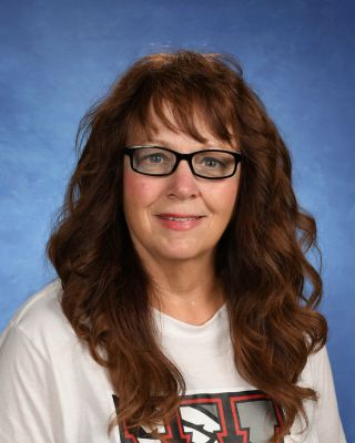 A woman wearing glasses and a white shirt is posing for a picture. This is Sharyn Cline.