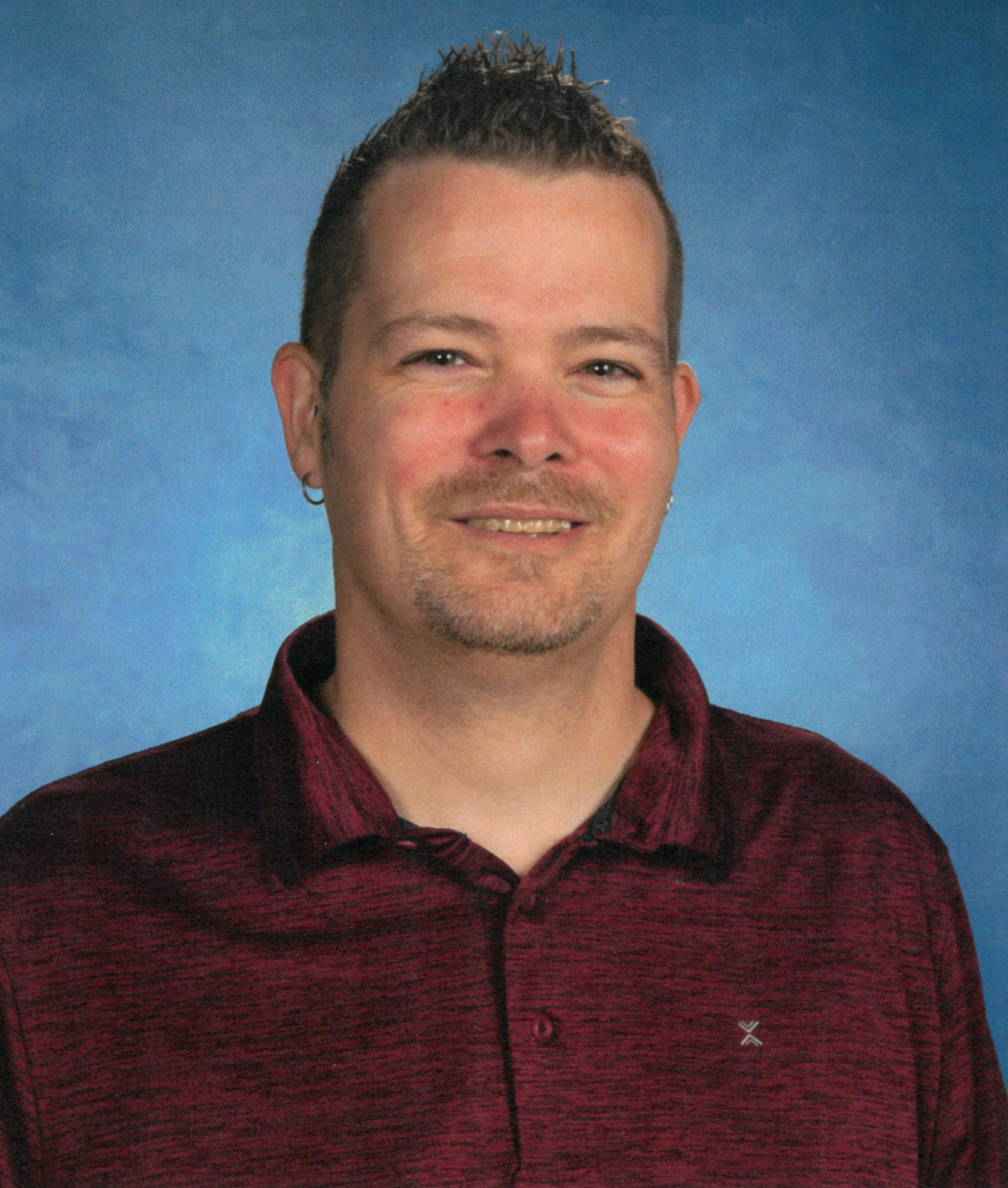 A man wearing a red shirt. This is Derek Morman.