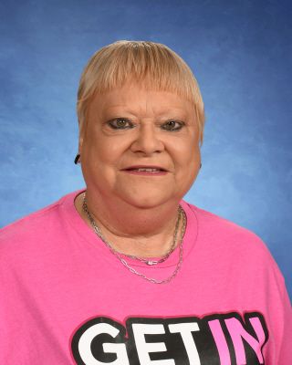A woman is wearing a pink shirt. This is Darlene Lampert.