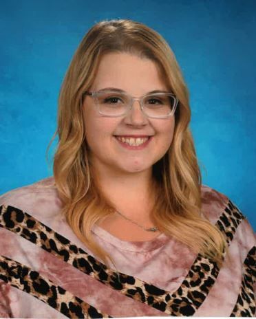 A woman is wearing a pink shirt. This is Darlene Lampert.