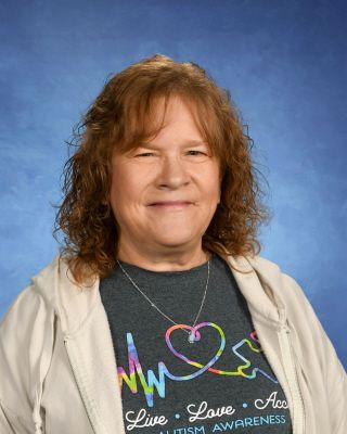 A woman is wearing a t-shirt with a heart on it and a necklace.