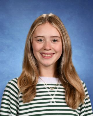 A woman wearing a floral shirt is smiling for the camera