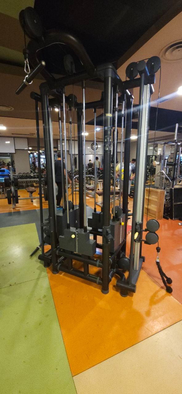 Macchina a cavi in ​​una palestra con barre cromate e pavimento arancione