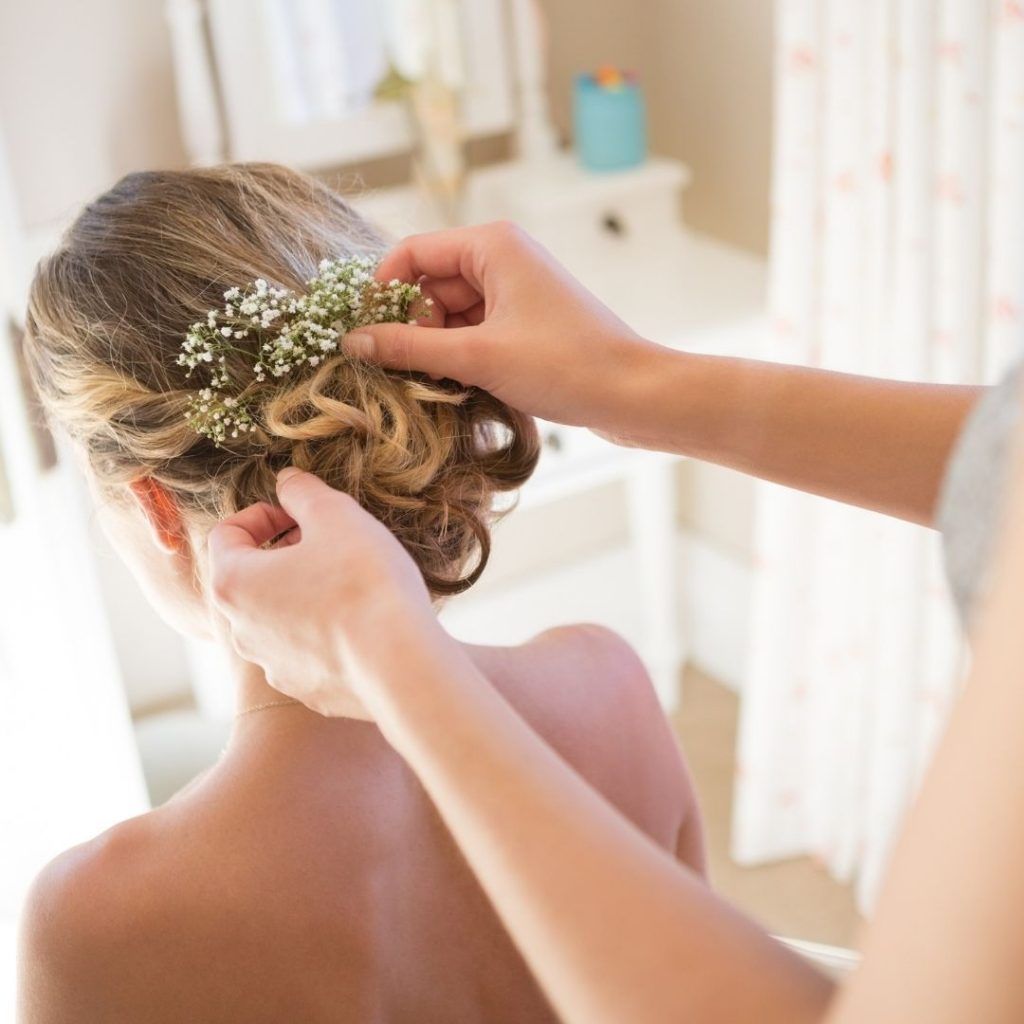 A woman is getting her hair done by a hairdresser.