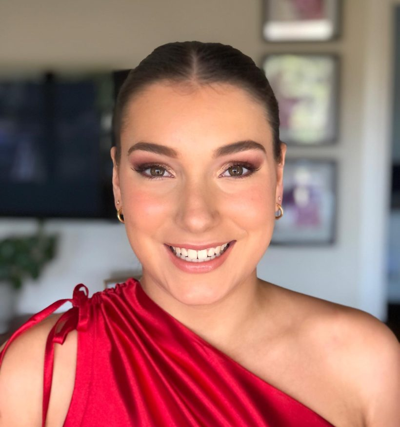 A woman in a red dress is smiling for the camera.