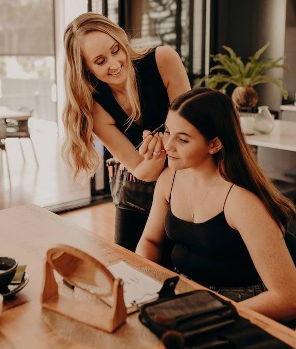 A woman is applying makeup to another woman 's face