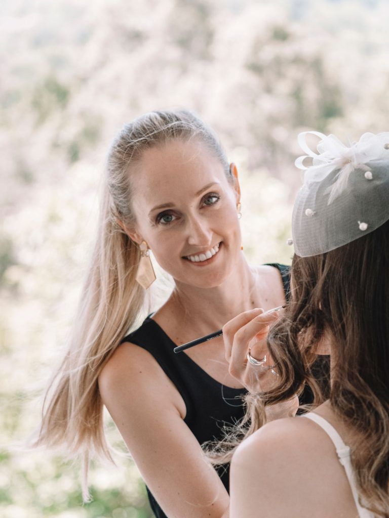 A woman is applying makeup to another woman 's face.