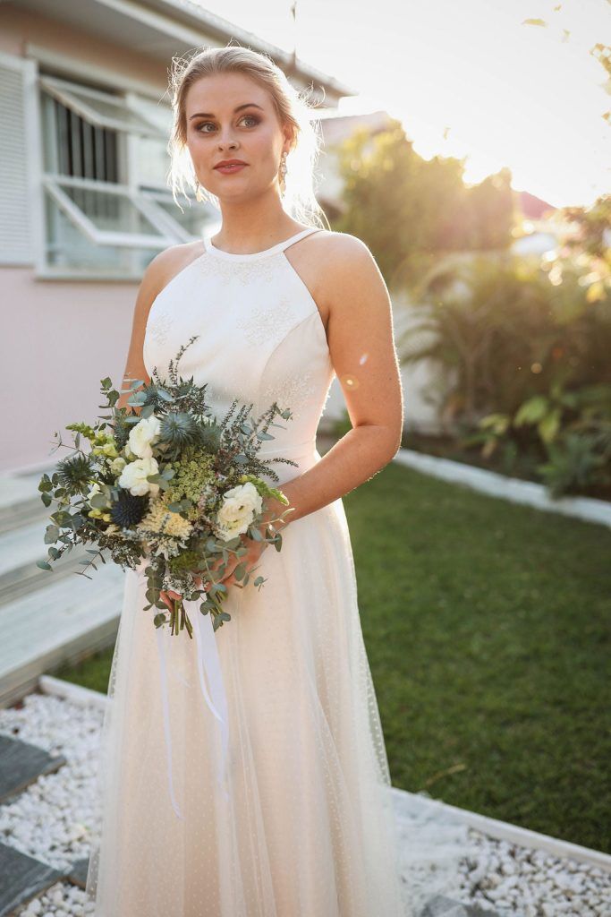 A woman in a wedding dress is holding a bouquet of flowers.
