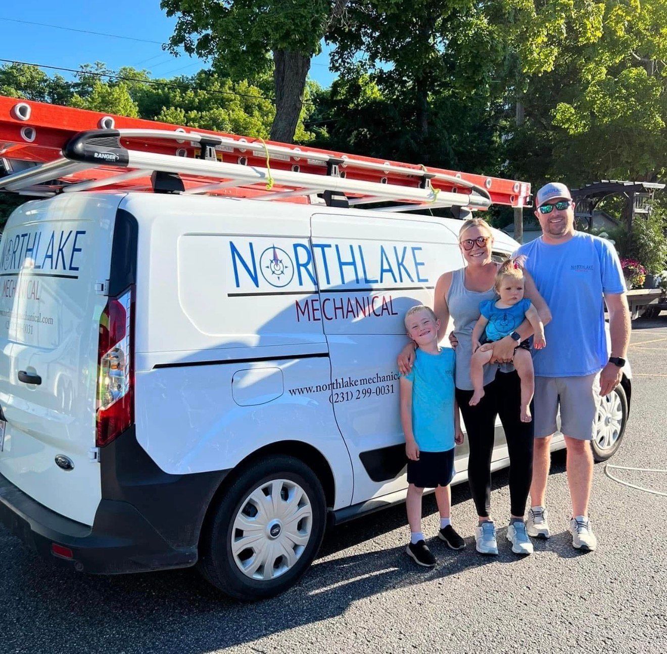 Northlake Mechanical van parked outside with a family posing beside it
