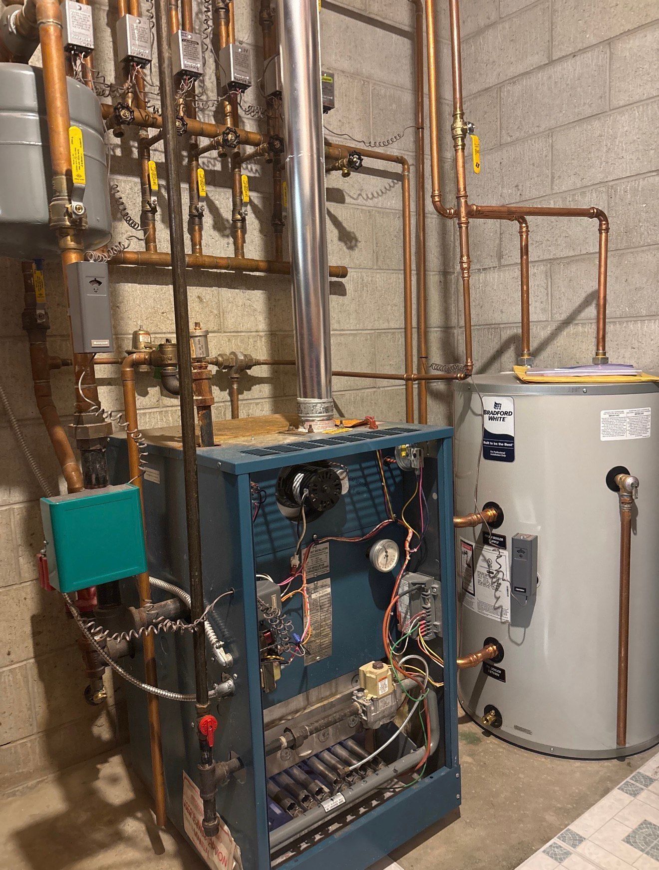 Basement utility room with HVAC equipment, water heater, and exposed copper pipes and ductwork.